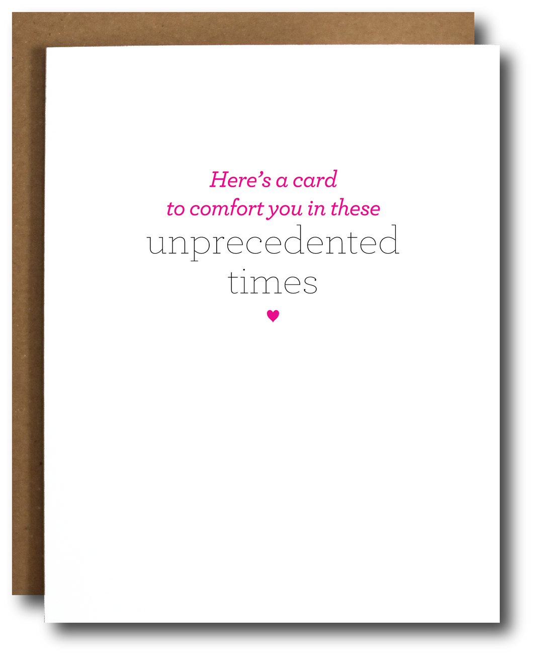 Minimalist greeting card with the message 'Here’s a card to comfort you in these unprecedented times' in pink and gray text, centered on a white background with a small pink heart below. Brown kraft paper envelope partially visible behind the card.