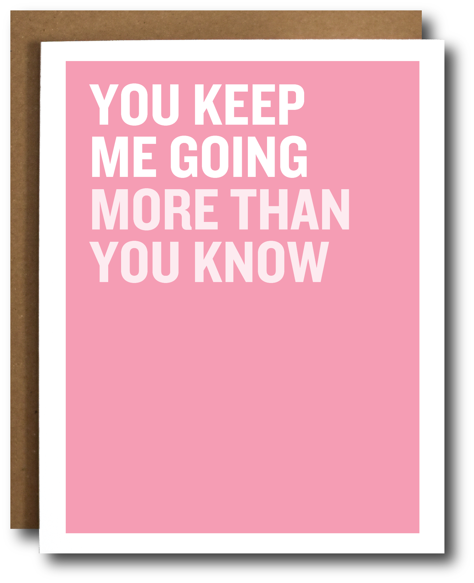 A pink greeting card with bold white text reading 'YOU KEEP ME GOING MORE THAN YOU KNOW' and a brown envelope behind it on a white background.