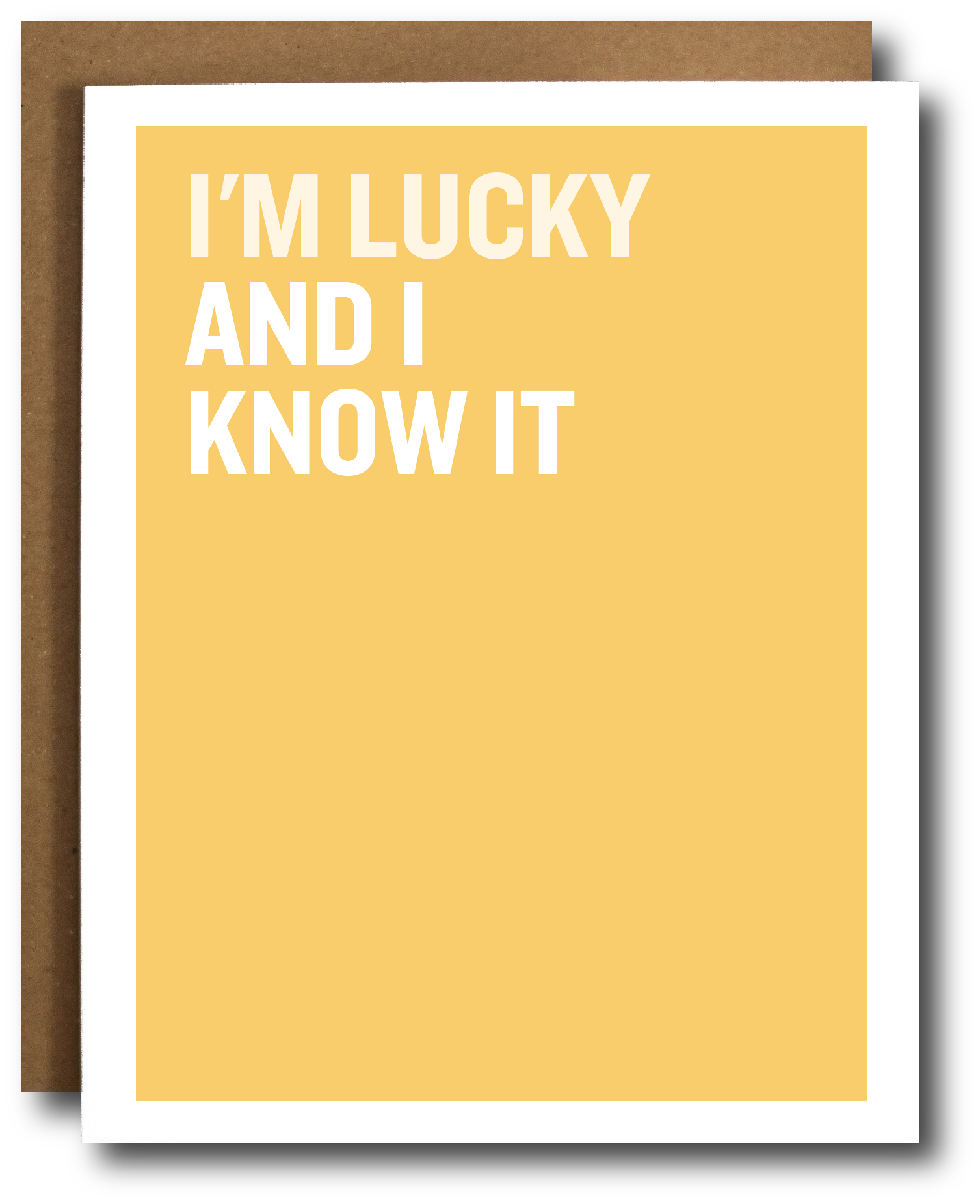 A yellow greeting card with bold white text reading 'I'M LUCKY AND I KNOW IT' stacked vertically, shown with a brown envelope behind it on a white background.