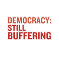 A die cut sticker with the text 'DEMOCRACY: STILL BUFFERING' in large red letters.