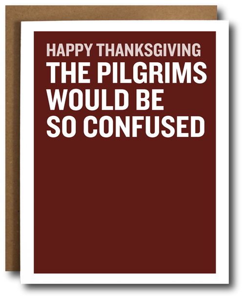 A Thanksgiving greeting card with a dark red background and bold white text reading 'HAPPY THANKSGIVING THE PILGRIMS WOULD BE SO CONFUSED,' shown with a brown envelope behind it on a white background.