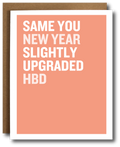 Greeting card with text 'SAME YOU NEW YEAR SLIGHTLY UPGRADED HBD' on a peach background with a brown envelope.