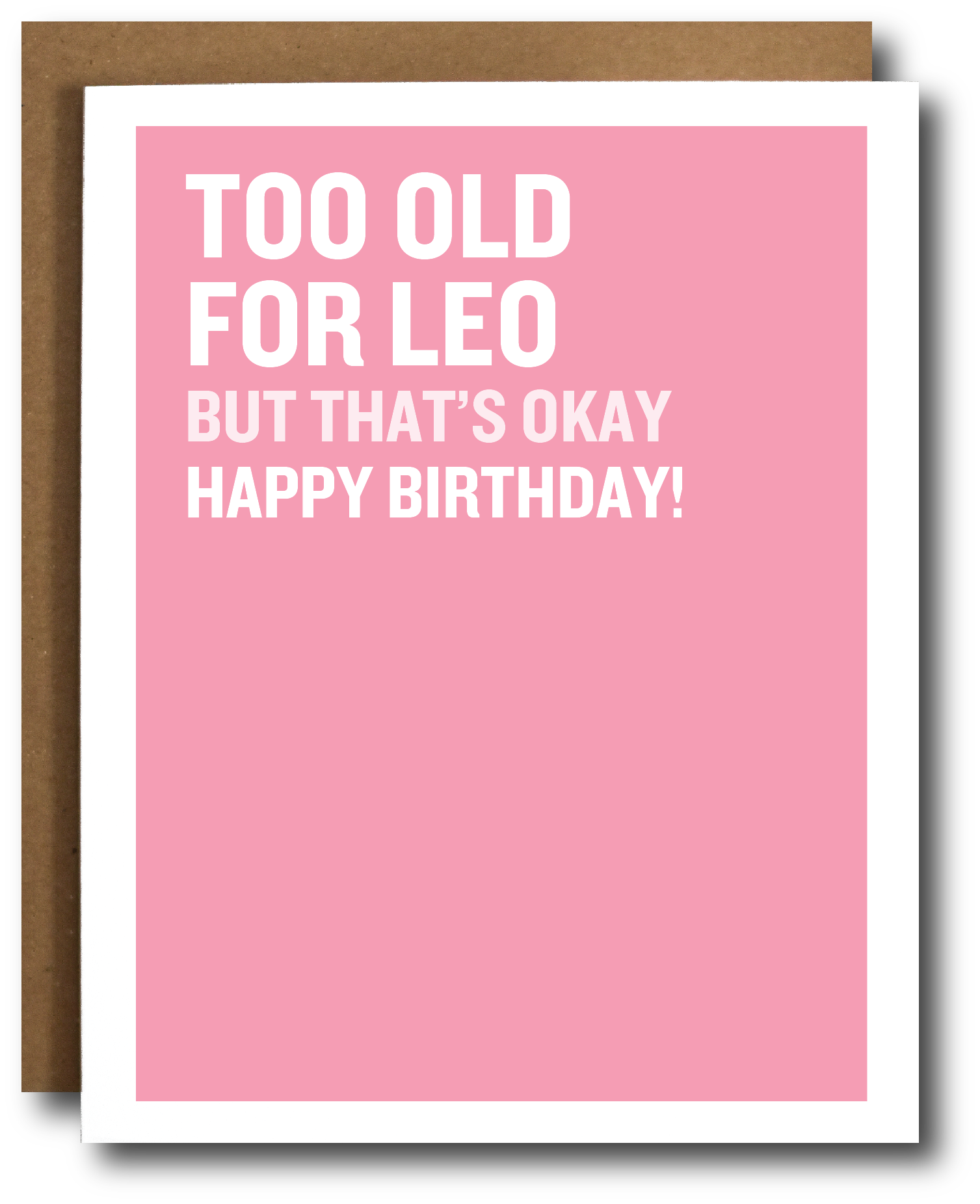 A pink greeting card with bold white text reading 'TOO OLD FOR LEO BUT THAT'S OKAY HAPPY BIRTHDAY!' shown with a brown envelope behind it on a white background.