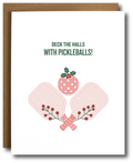 A holiday greeting card with a depiction of pickleball paddles and a stylized Christmas tree, with the text 'DECK THE HALLS WITH PICKLEBALLS!' on the front.