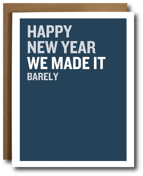 A greeting card with a dark blue front and white border, shown with a brown envelope behind it. The card reads, 'HAPPY NEW YEAR WE MADE IT BARELY' in white uppercase text.
