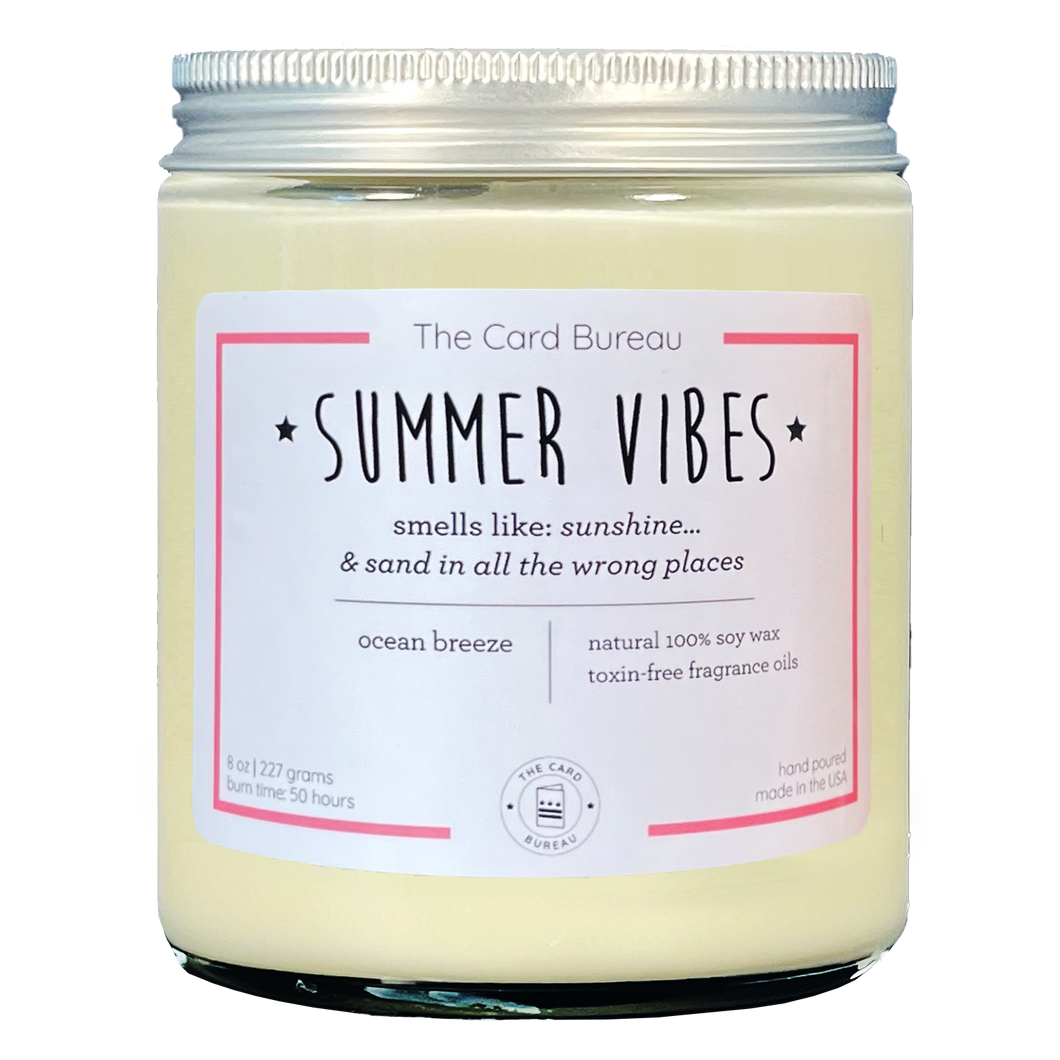Photo of Summer Vibes 8ounce 50 hour soy wax candle in glass jar with tin lid. Tagline reads Smells like sunshine... and sand in all the wrong places. scent is ocean breeze