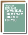 A greeting card with a sage green background and bold white text reading, 'THIS CARD IS TOO SMALL TO WRITE ALL THE WAYS I’M THANKFUL FOR YOU,' shown with a brown kraft envelope behind it on a white background.