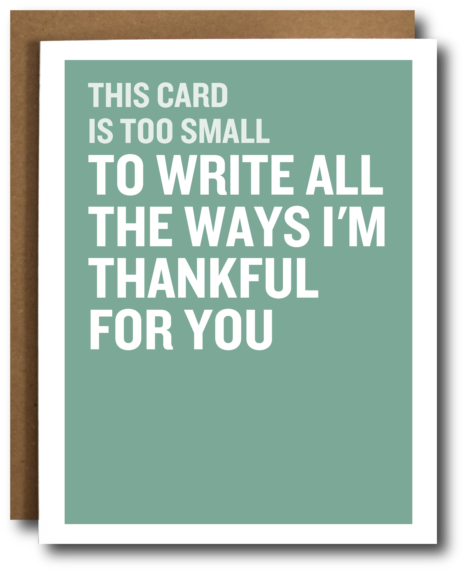 A greeting card with a sage green background and bold white text reading, 'THIS CARD IS TOO SMALL TO WRITE ALL THE WAYS I’M THANKFUL FOR YOU,' shown with a brown kraft envelope behind it on a white background.
