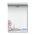 A lined notepad with a rolled top edge, featuring a hand-drawn illustration of cherry blossom trees, the Washington Monument, and a waterfront scene. The word 'Notes' appears at the top in cursive.