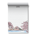 A lined notepad with a rolled top edge, featuring a hand-drawn illustration of cherry blossom trees, the Jefferson memorial, and a waterfront scene. The word 'Notes' appears at the top in cursive.